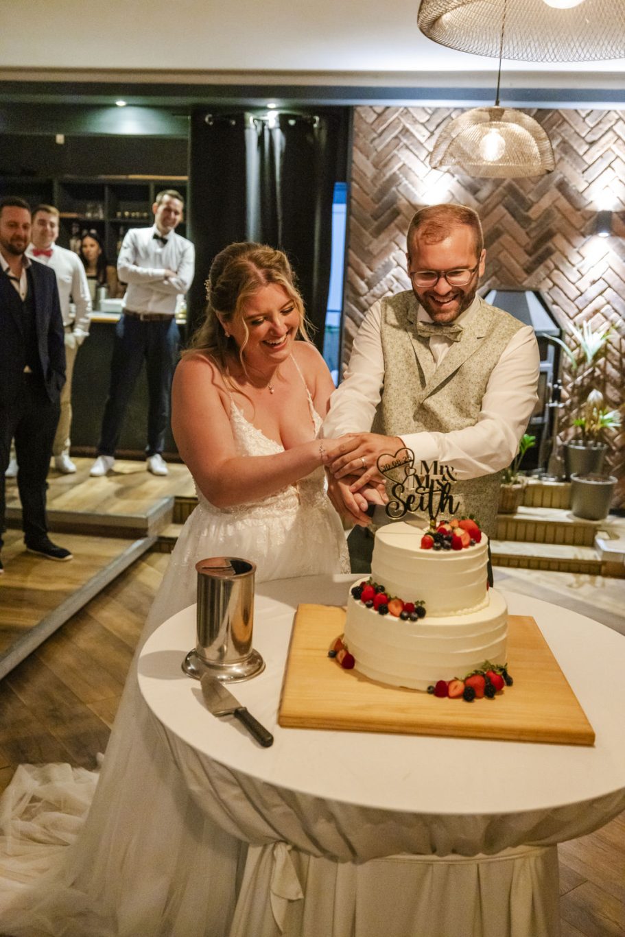 Braut und Bräutigam schneiden gemeinsam die Hochzeitstorte an