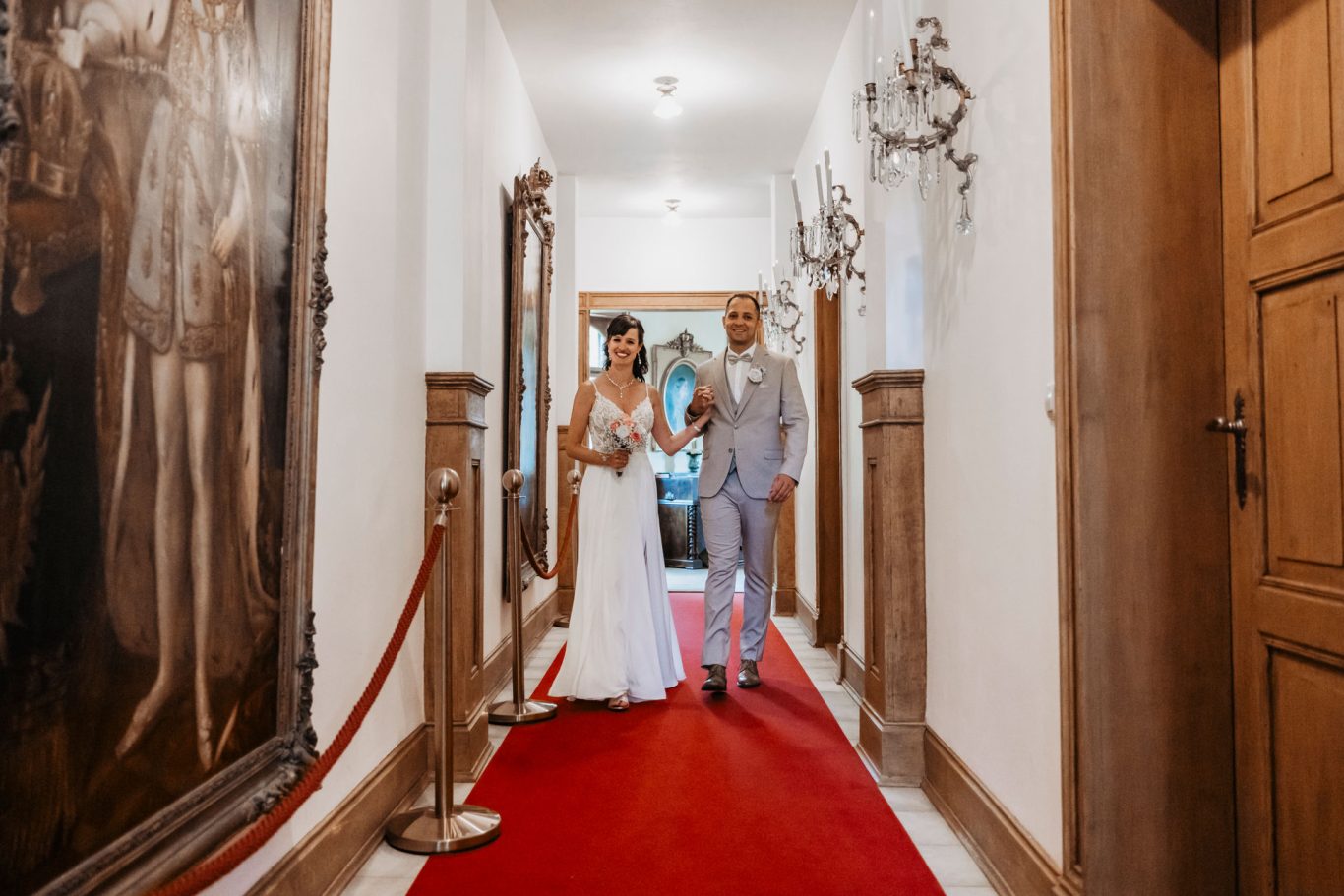 Brautpaar auf einem roten Teppich in einem elegant dekorierten Flur im Schloss Lichtenstein