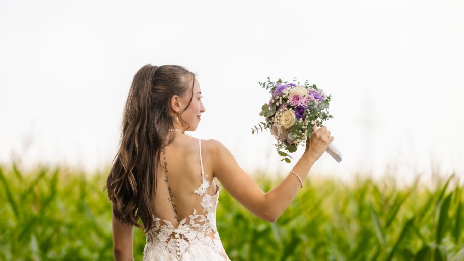 Braut mit Blumen in der Landschaft