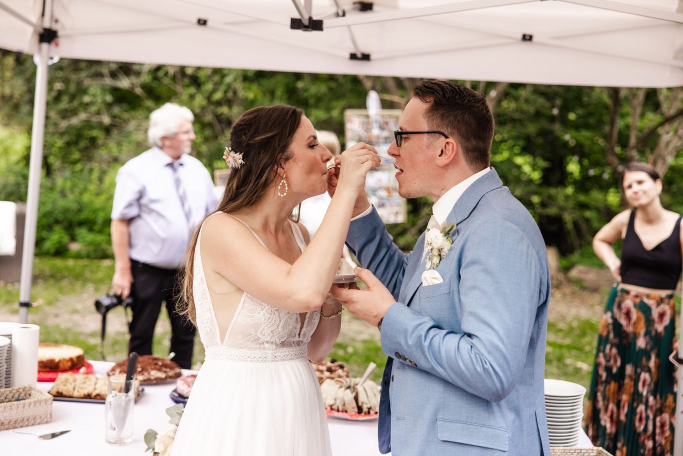 Brautpaar schneidet gemeinsam die Hochzeitstorte bei der Hochzeitsfeier