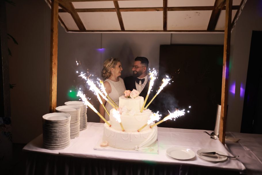 Brautpaar mit der Hochzeitstorte bei der Feier