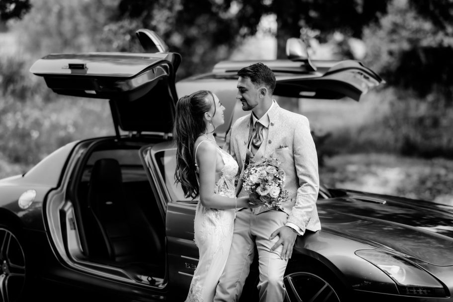 Brautpaar am Auto beim Hochzeitsshooting in Schwarzweiß