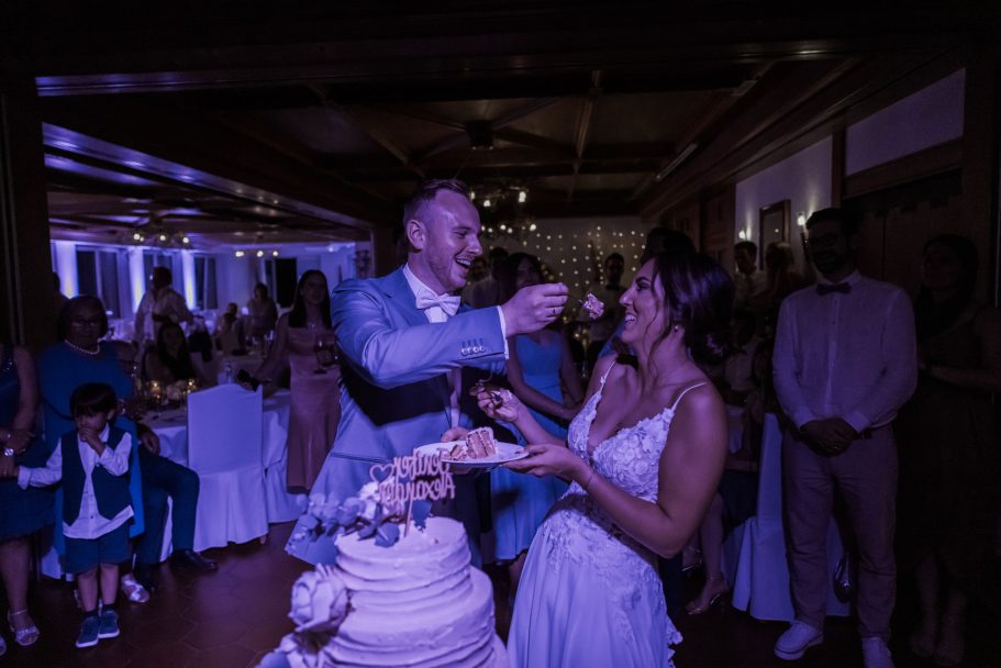Brautpaar beim Hochzeitstanz mit der Hochzeitstorte im Hintergrund