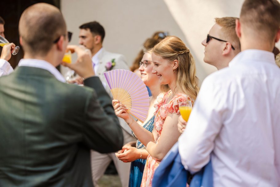 Brautpaar und Gäste stoßen beim Sektempfang auf die Hochzeit an