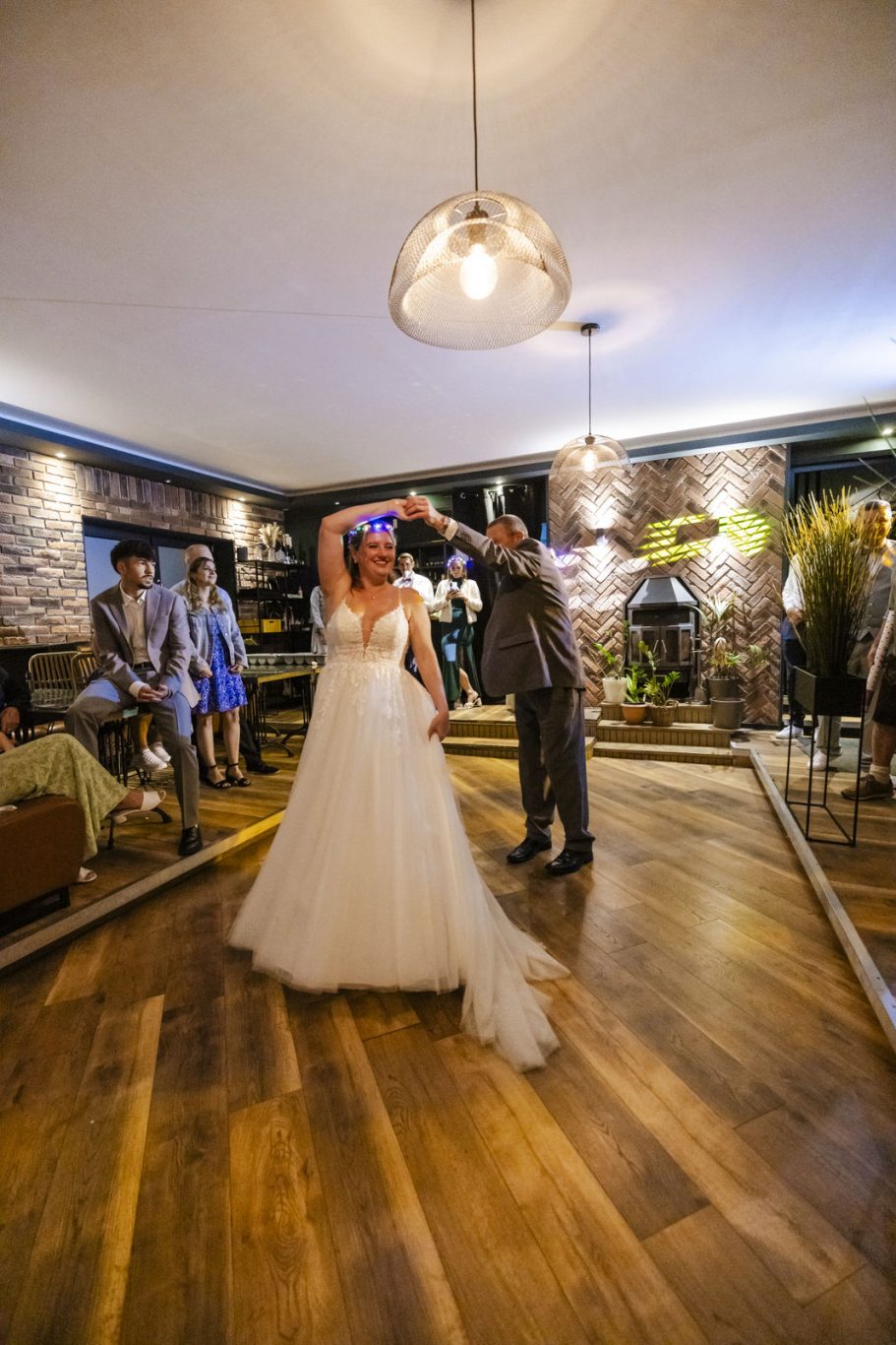 Brautpaar beim Hochzeitstanz mit den Gästen im Hintergrund