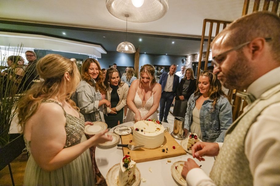 Hochzeitstorte wird nach dem Anschneiden an die Gäste verteilt