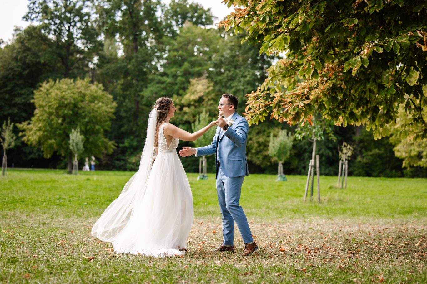 Brautpaar bewegt sich lachend beim Hochzeitsshooting im Grünen