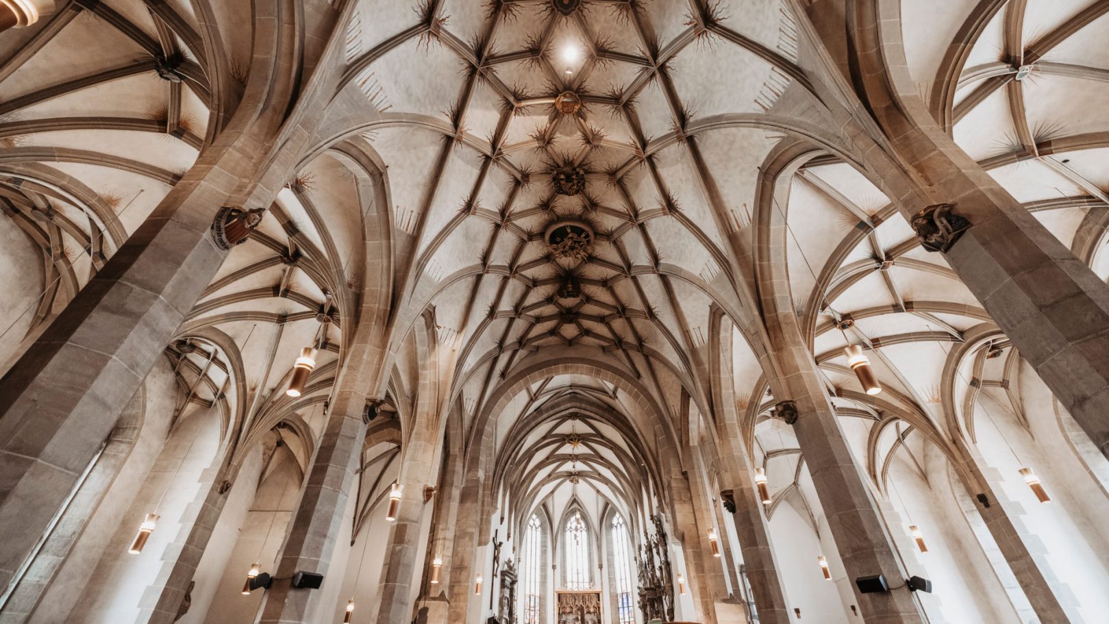Innenansicht von Stiftskirche Öhringen mit hohen gewölbten Decken und filigranen Säulen.