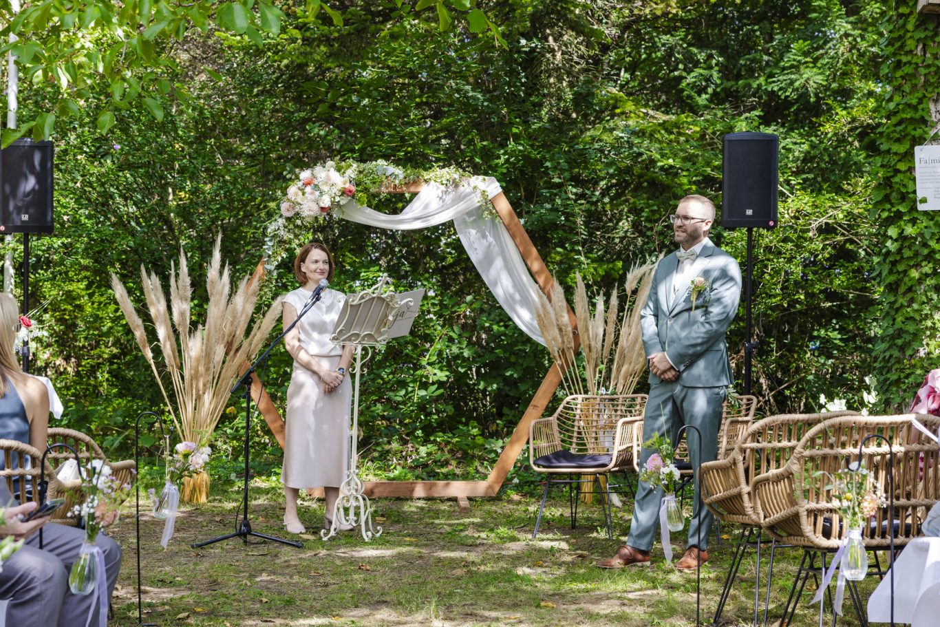 Freie Trauung des Brautpaares unter einem Blumenbogen im The Woods Ketsch