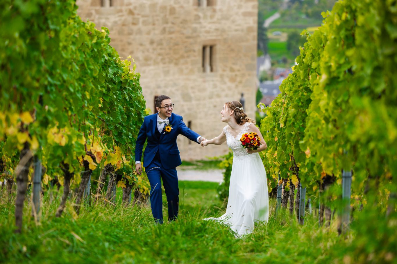 Brautpaar geht gemeinsam durch die Weinberge bei der Y-Burg