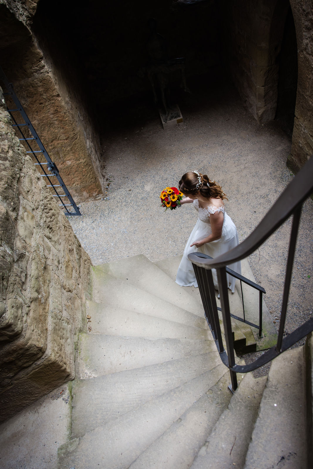 Braut auf der Treppe der Y-Burg beim First Look